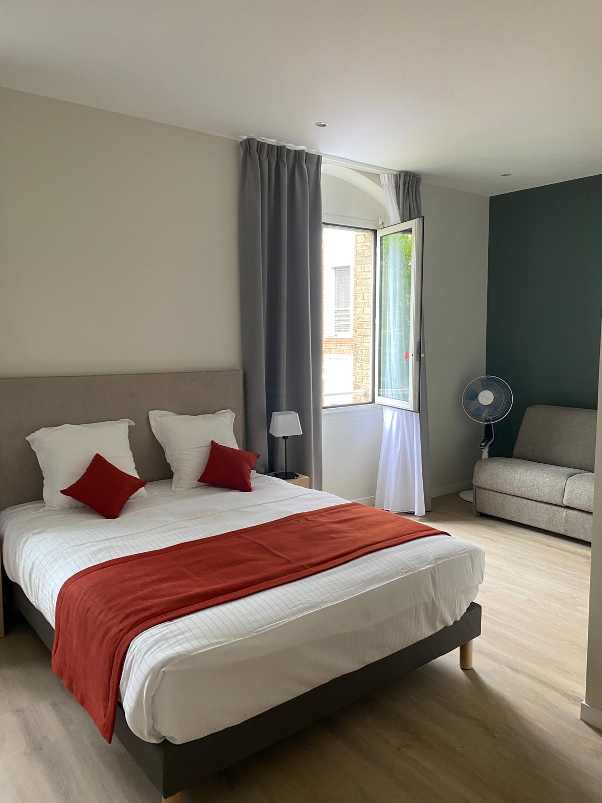 Chambre rénovée avec mur d'accent peint et sol imitation bois