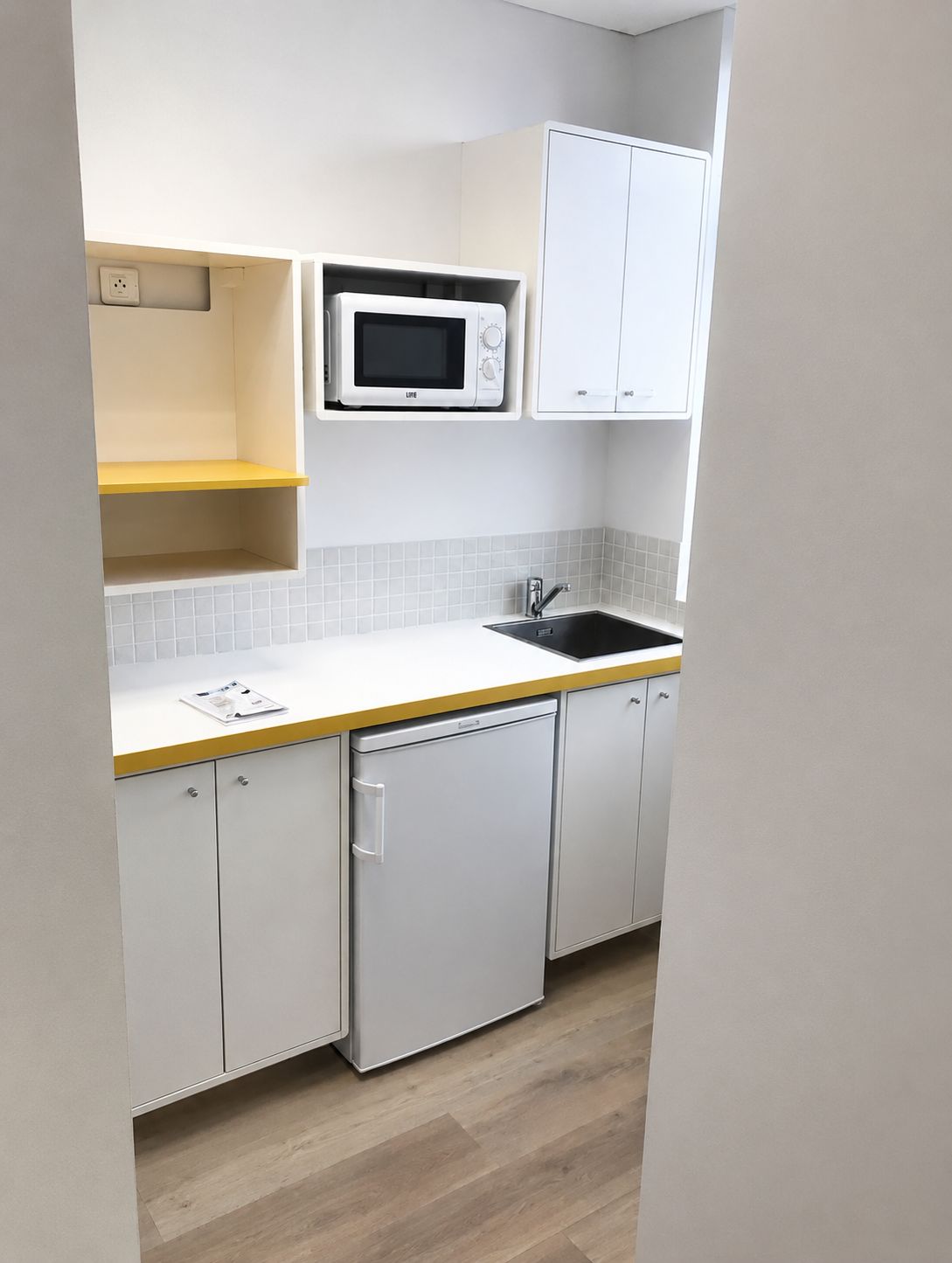 Espace kitchenette avec plan de travail et rangements